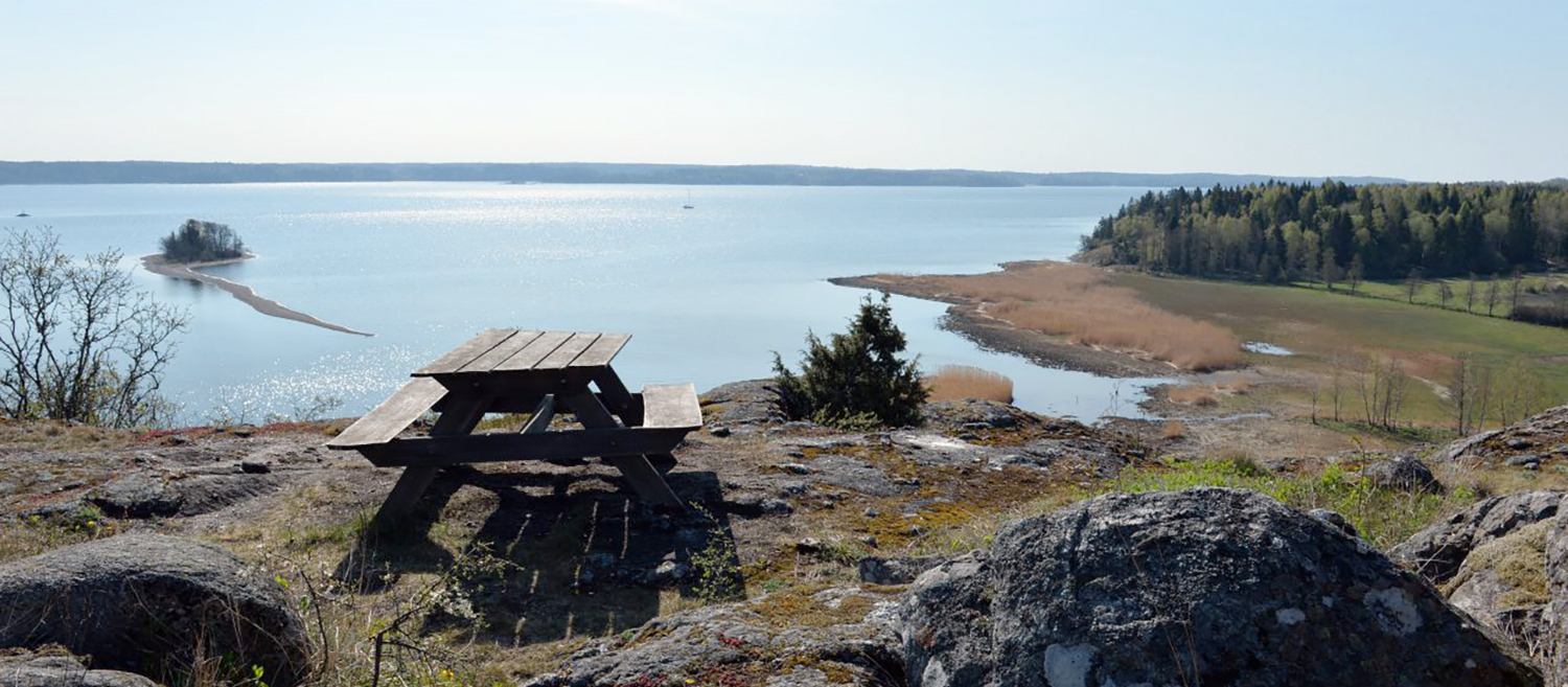 Bänk på berg med utsikt över vatten
