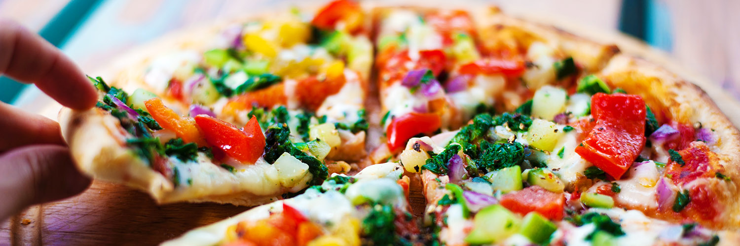 Hand som tar bit från pizza